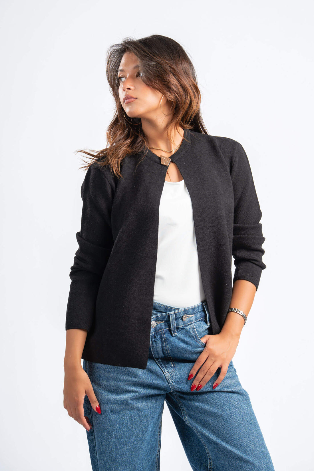 Woman wearing a black jacket, white shirt, and blue jeans on a white background
