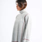 Woman wearing a ribbed sweater with a white background