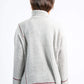 Person wearing a light gray ribbed sweater with red accents on a white background