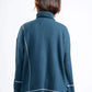 Person wearing a blue ribbed sweater with white trim on a white background