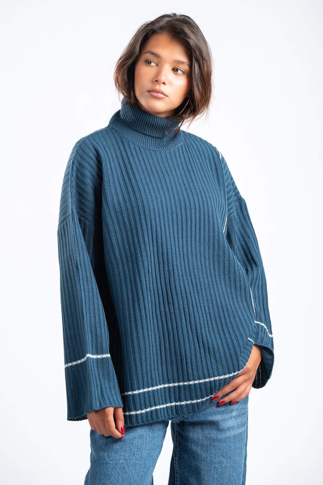 Person wearing a blue ribbed sweater with white trim on a white background