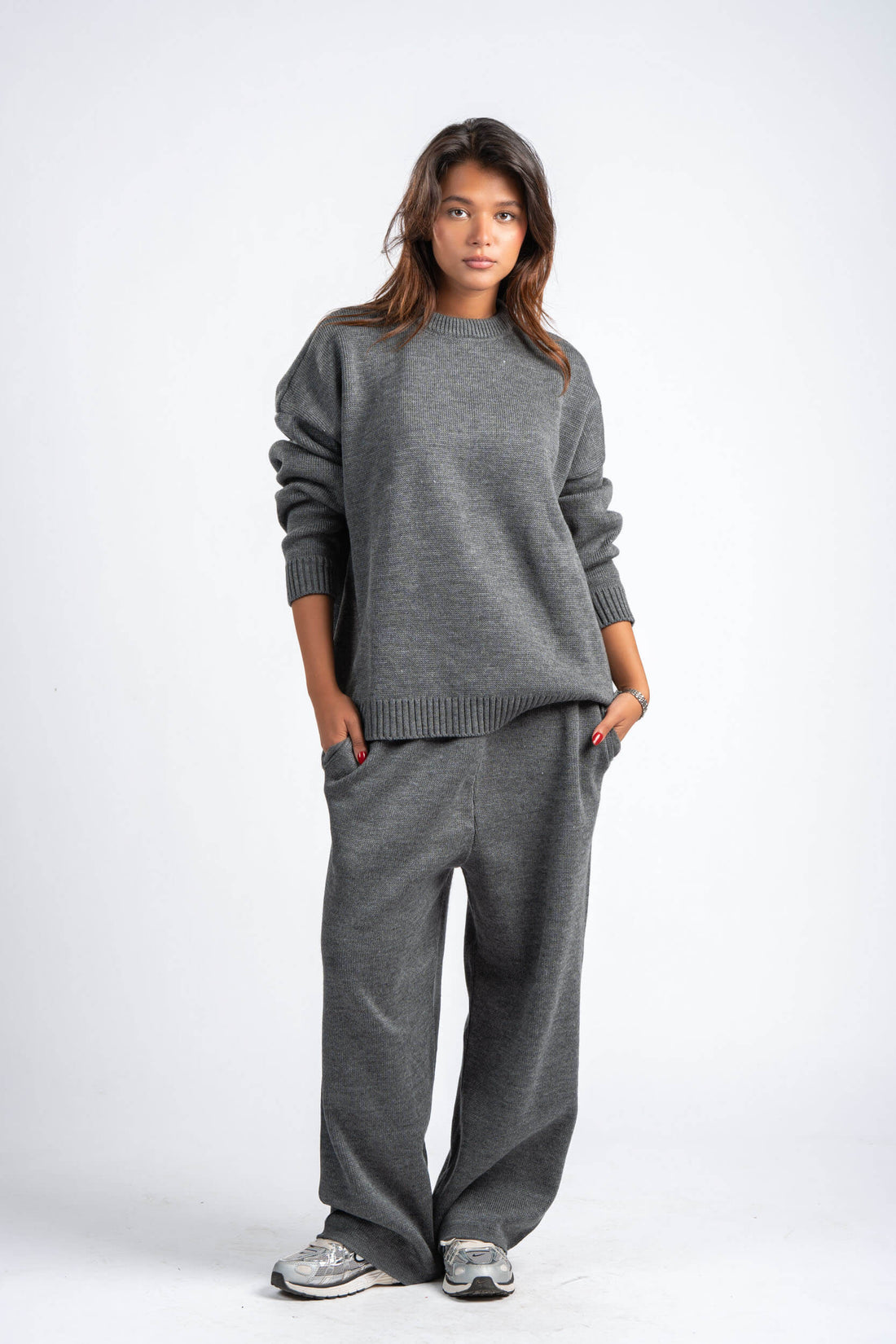 Two people wearing matching gray sweaters and pants on a white background