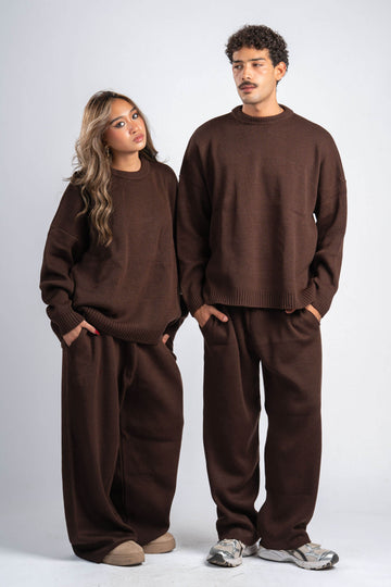 Two people wearing matching brown outfits on a white background