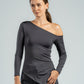 Woman wearing a gray one-shoulder top against a plain background