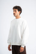 Person wearing a white sweatshirt on a plain background