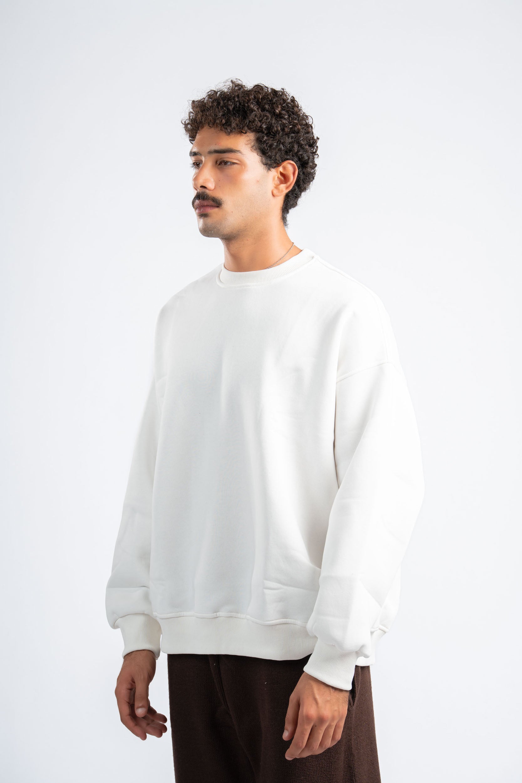 Person wearing a white sweatshirt on a plain background