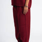 Person wearing a burgundy sweater and pants on a white background