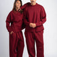 Two people wearing matching red sweatsuits on a white background