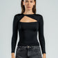 Woman wearing a black long-sleeve top with a unique design, standing against a plain background.