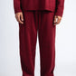 Person wearing a red sweater and matching pants on a white background