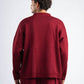 Person wearing a burgundy sweater and pants on a white background
