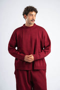 Man wearing a red sweater and pants on a white background