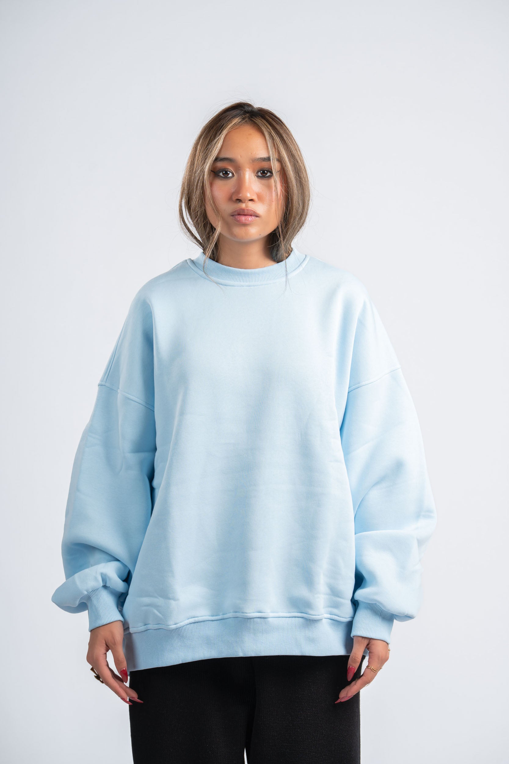 Person wearing a light blue sweatshirt against a white background