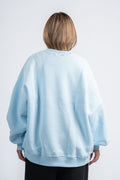 Person wearing a light blue sweatshirt on a white background
