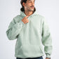 Man wearing a light green hoodie on a white background