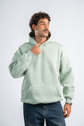 Man wearing a light green hoodie on a white background