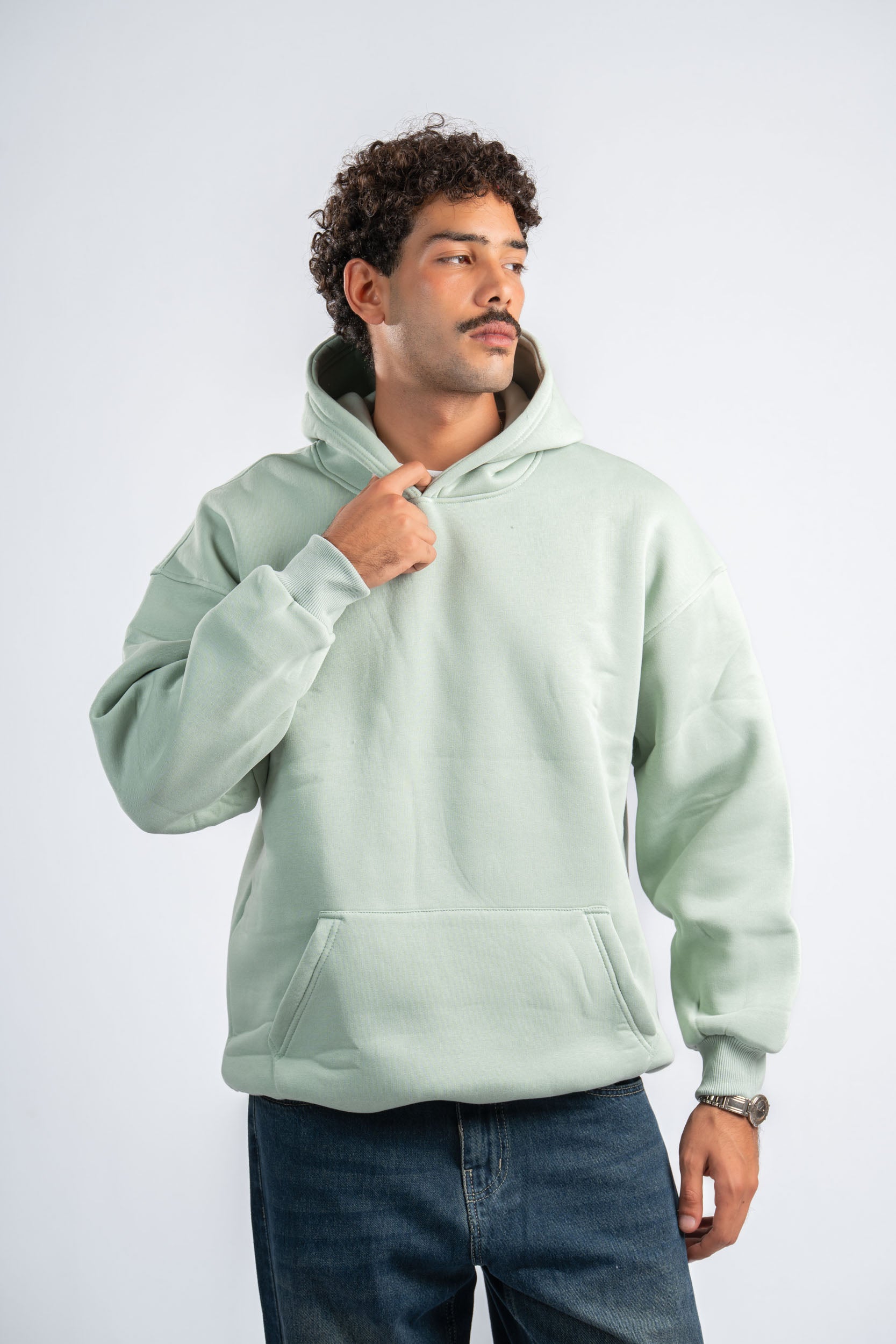 Man wearing a light green hoodie on a white background