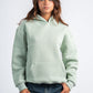 Person wearing a light green hoodie on a white background