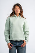 Person wearing a light green hoodie on a white background