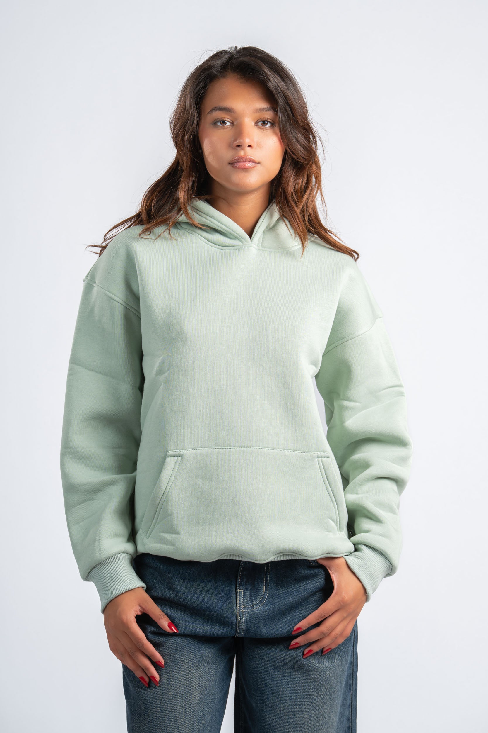 Person wearing a light green hoodie on a white background