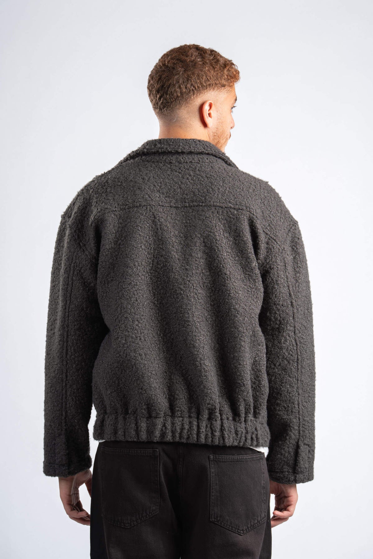 Person wearing a dark gray fleece jacket on a white background
