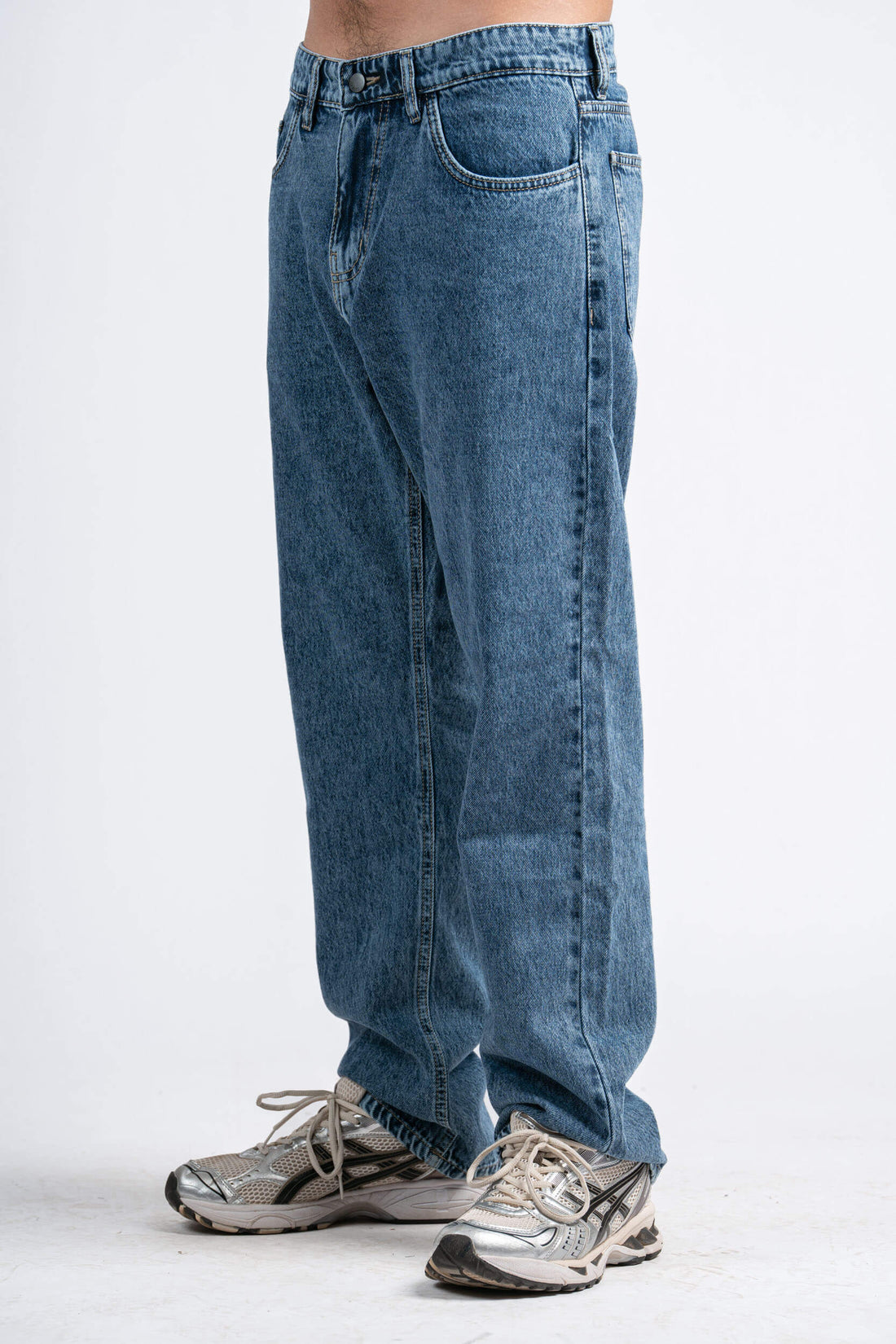 Blue jeans worn by a person on a white background