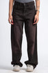 Person wearing dark brown wide-leg jeans on a white background