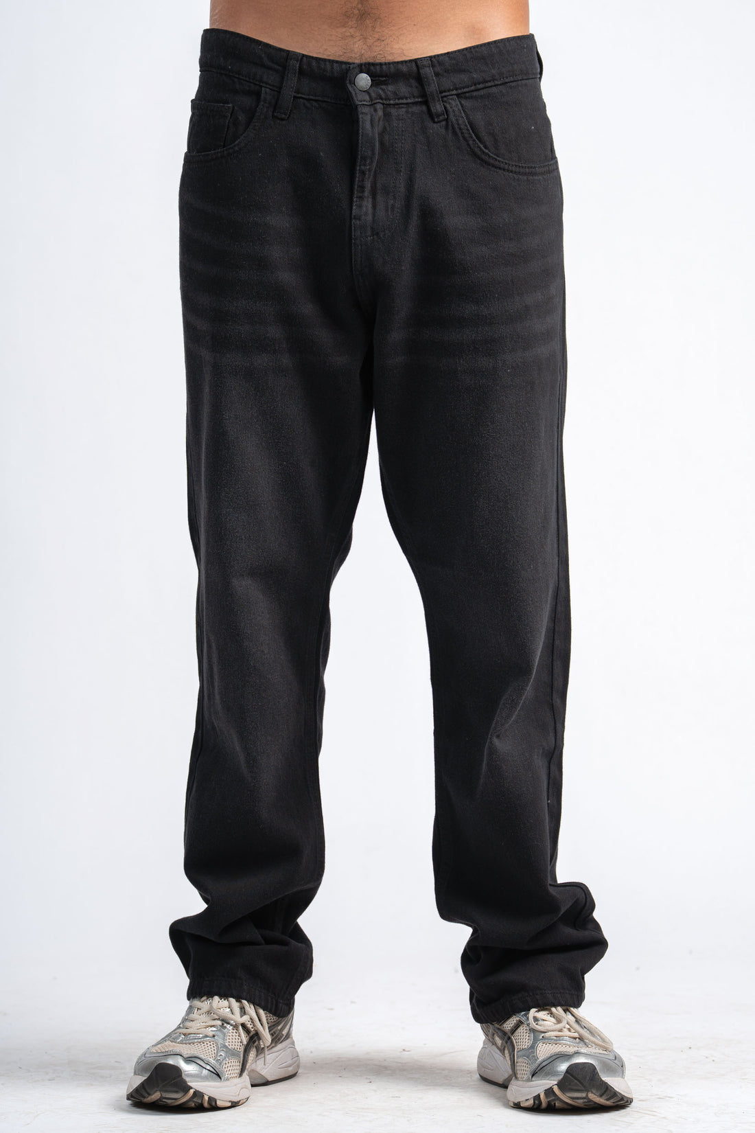 Person wearing black jeans on a white background