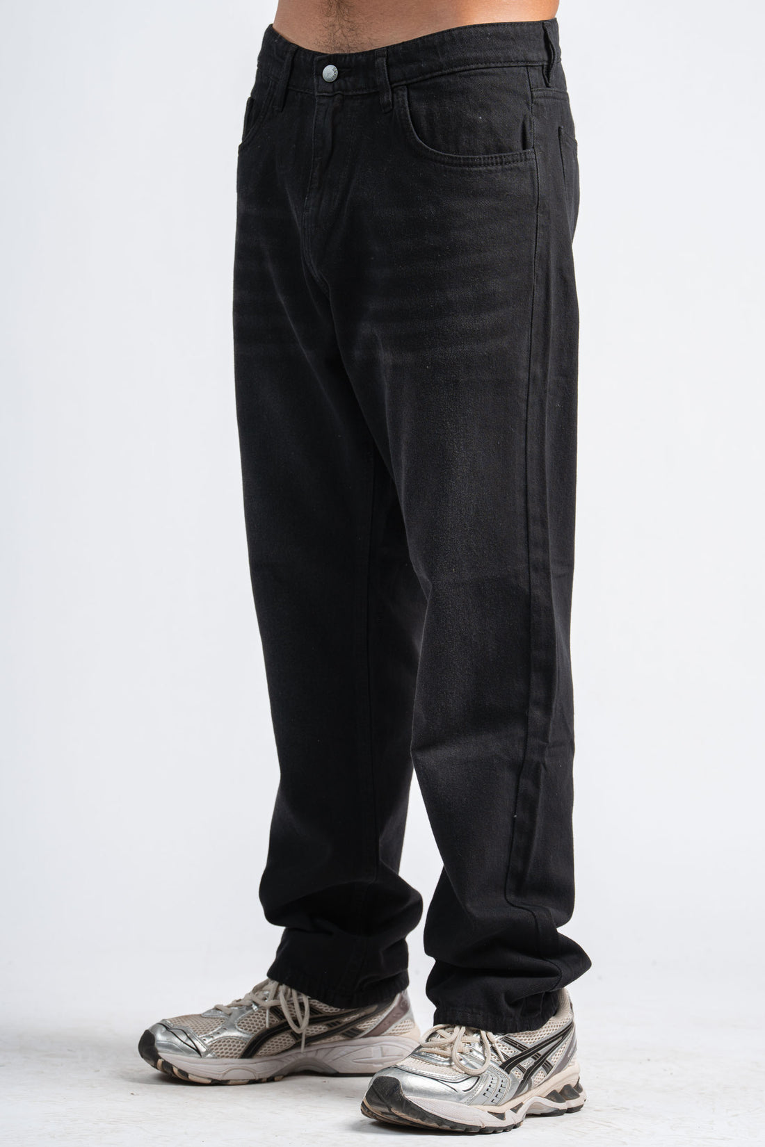 Person wearing black jeans on a white background