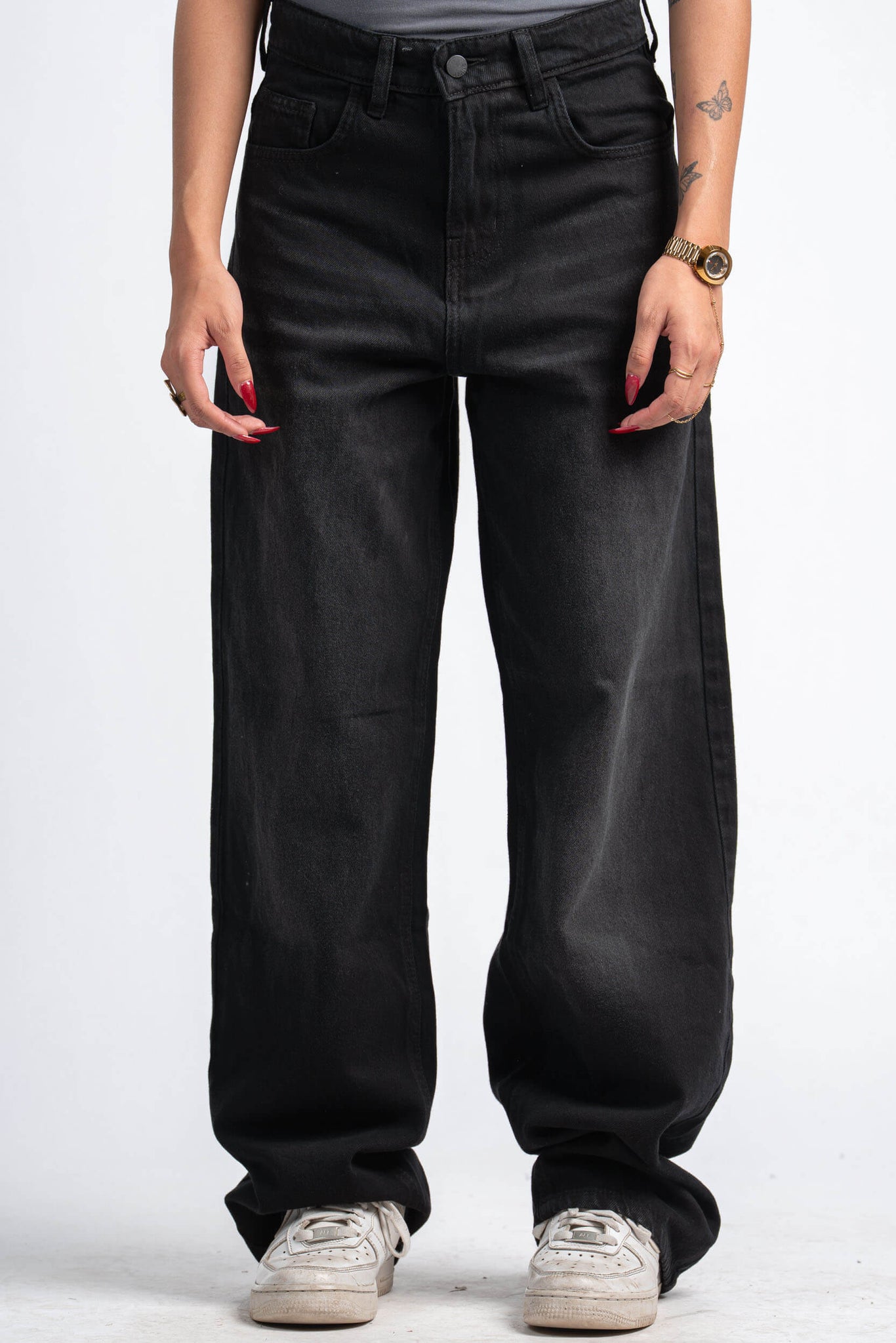 Person wearing black wide-leg jeans on a white background