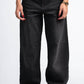 Person wearing black wide-leg jeans on a white background