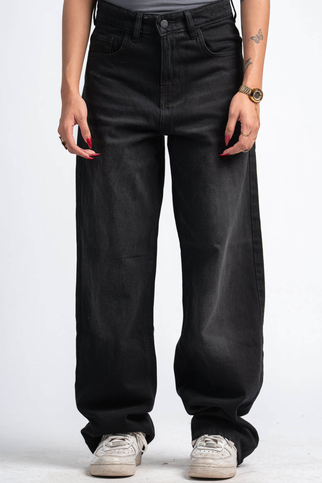 Person wearing black wide-leg jeans on a white background