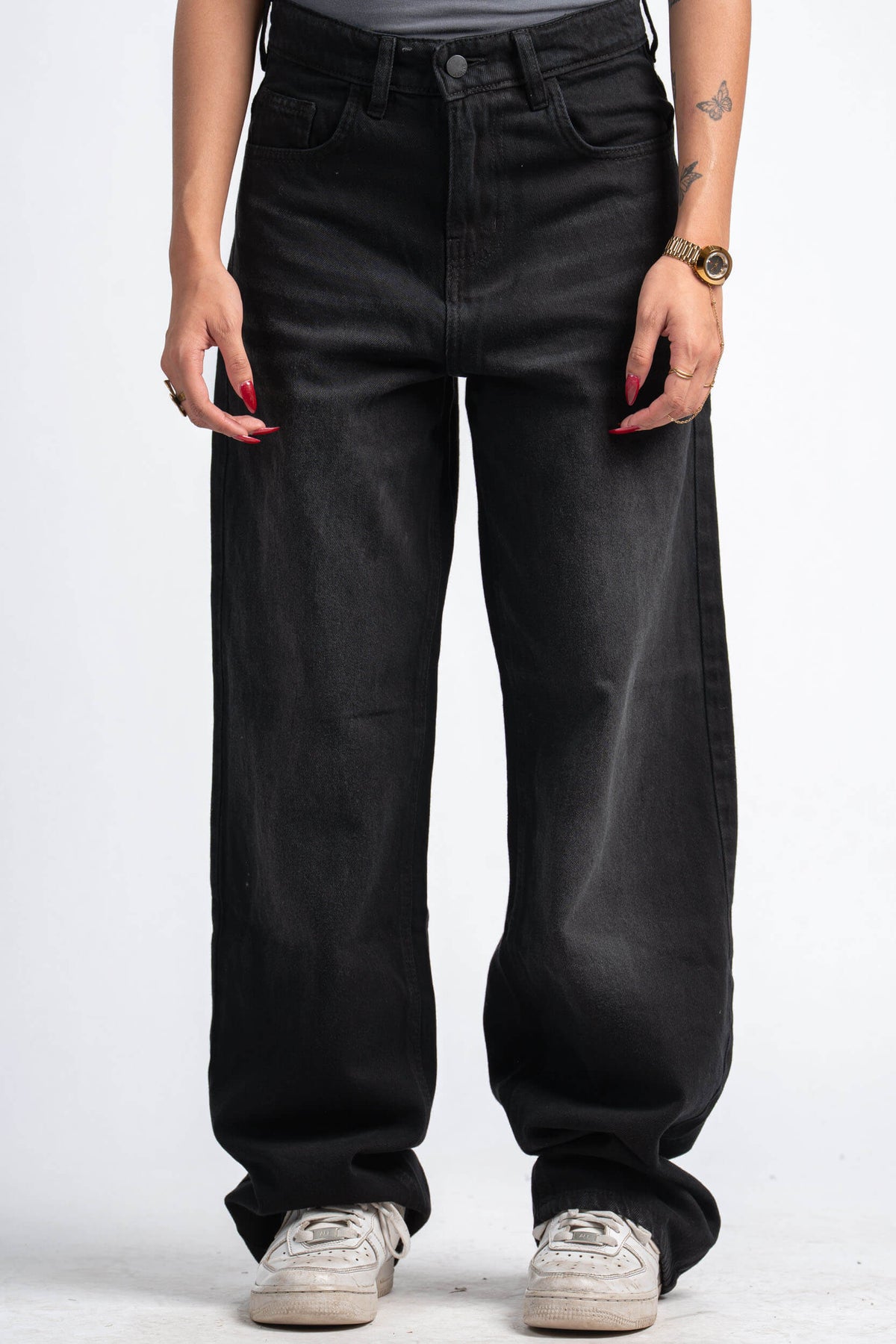 Person wearing black wide-leg jeans on a white background