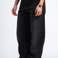 Person wearing black wide-leg jeans on a white background