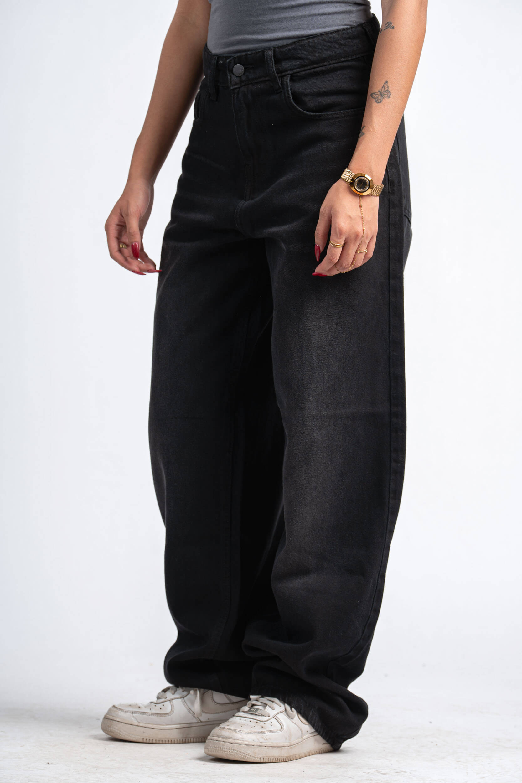 Person wearing black wide-leg jeans on a white background