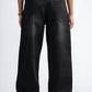 Person wearing black wide-leg pants on a white background