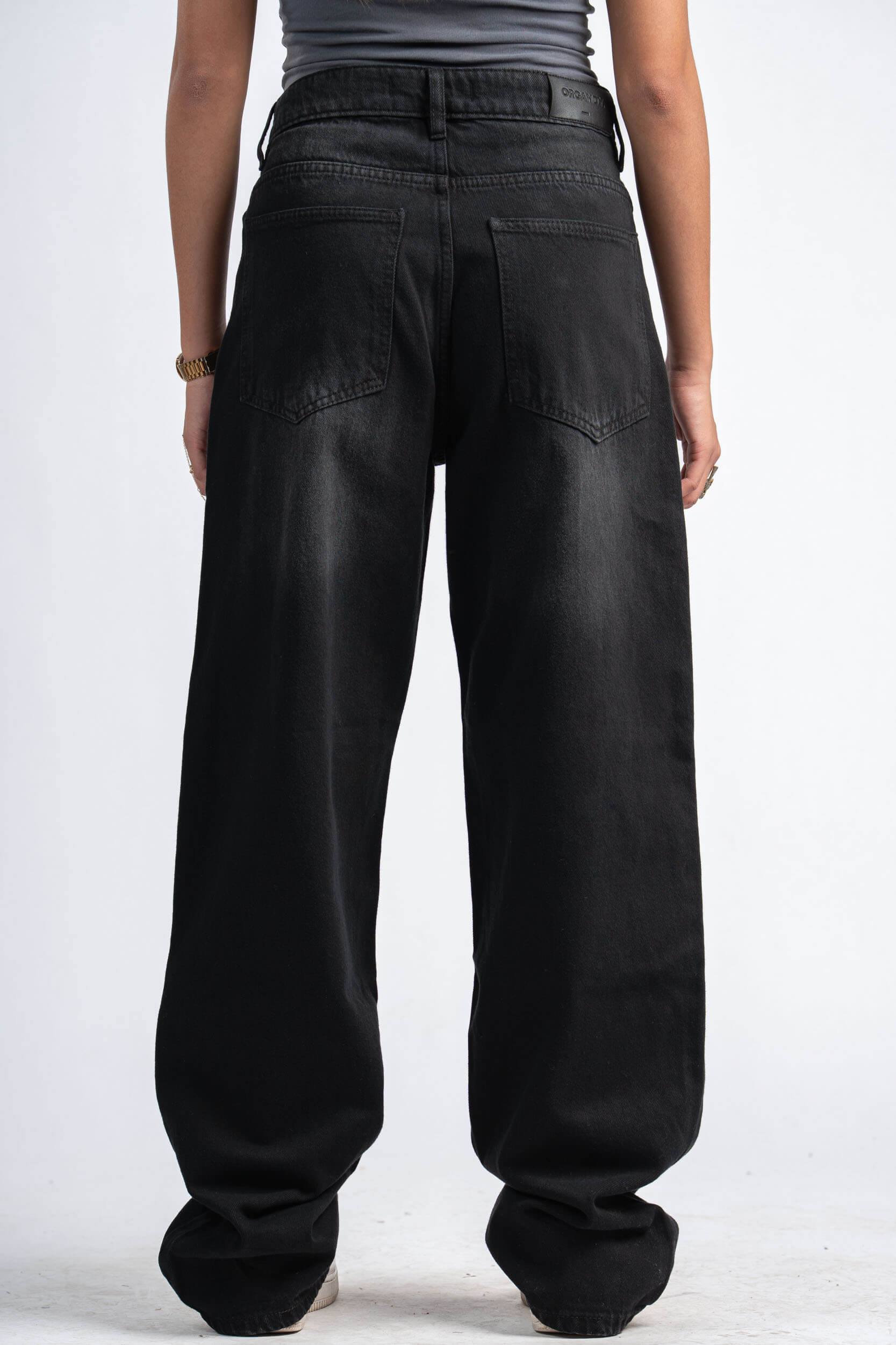 Person wearing black wide-leg pants on a white background