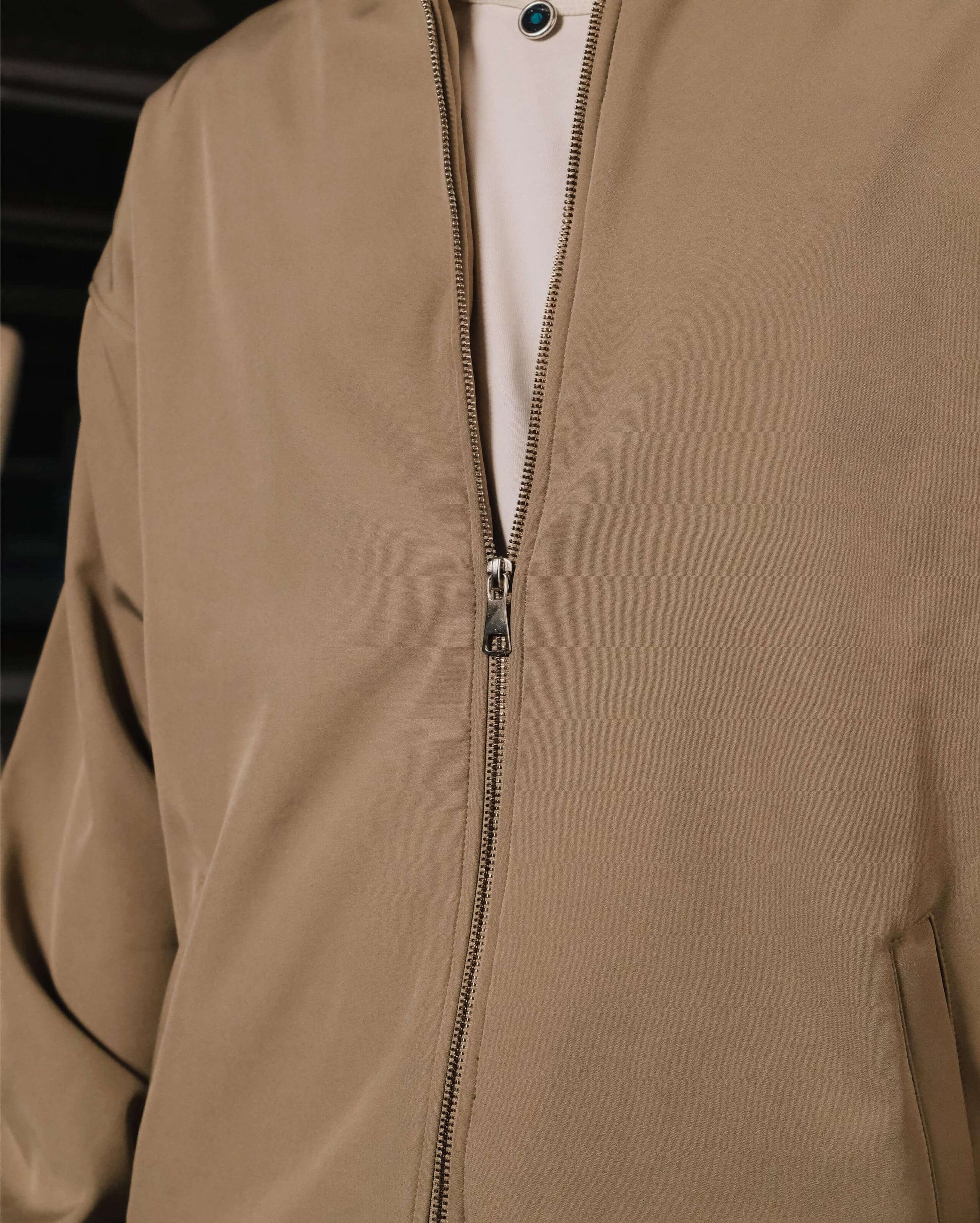 Close-up of a beige jacket with a zipper