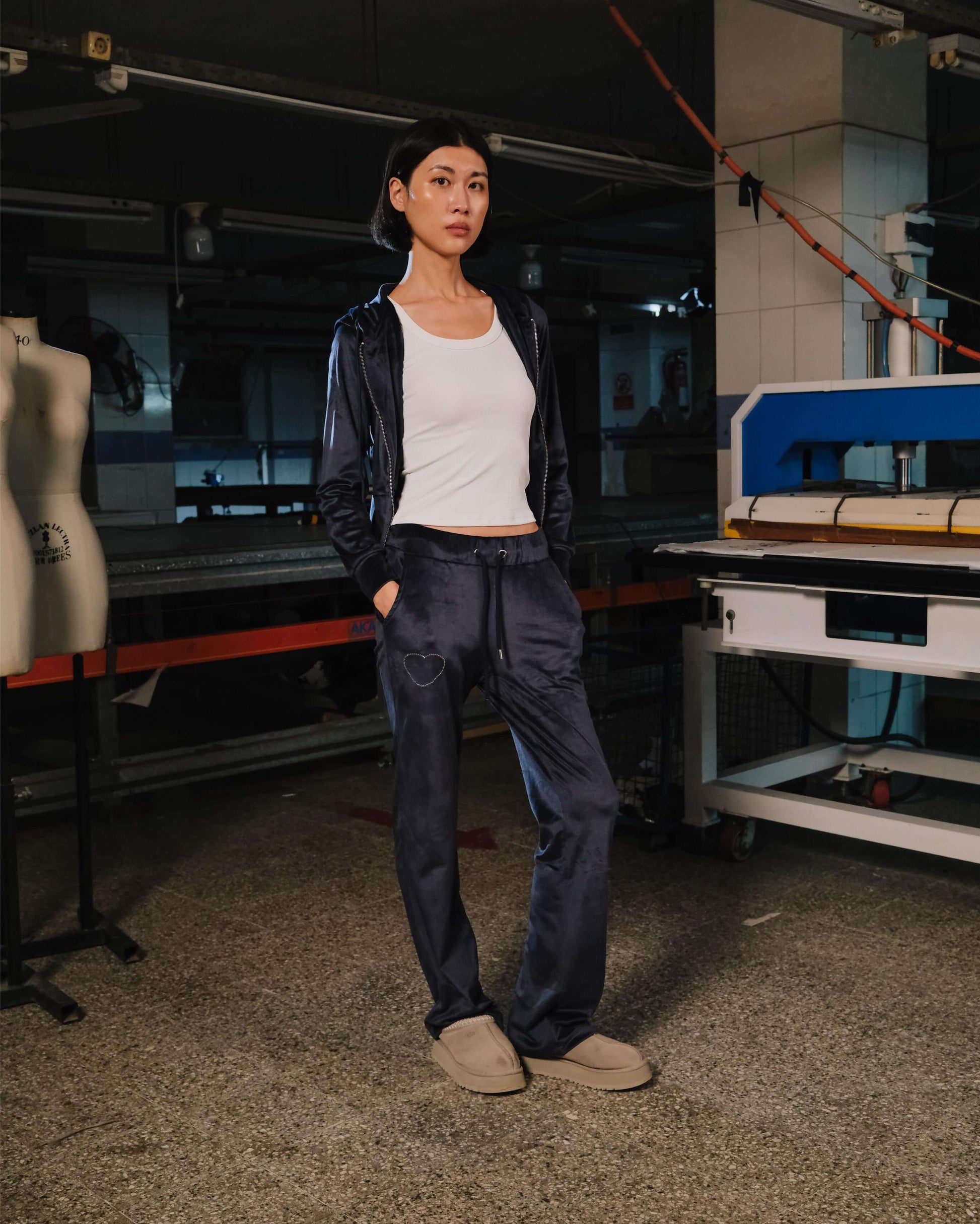 Person wearing a dark jacket and pants in an industrial setting