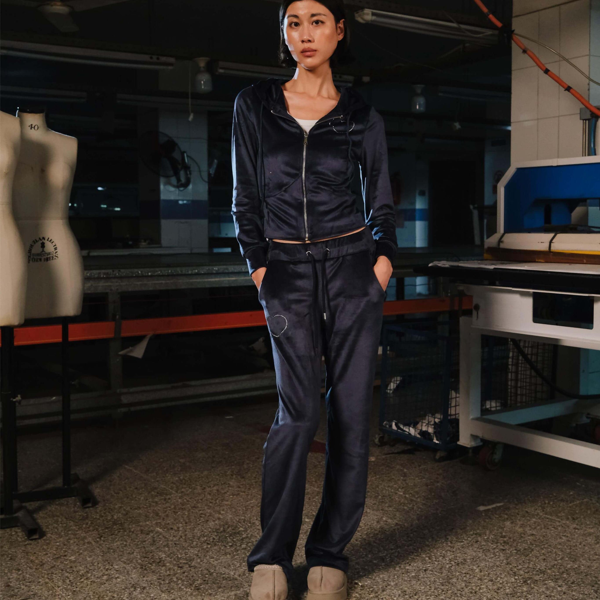 Person wearing a navy tracksuit in a workshop setting