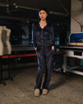 Person wearing a navy tracksuit in a workshop setting