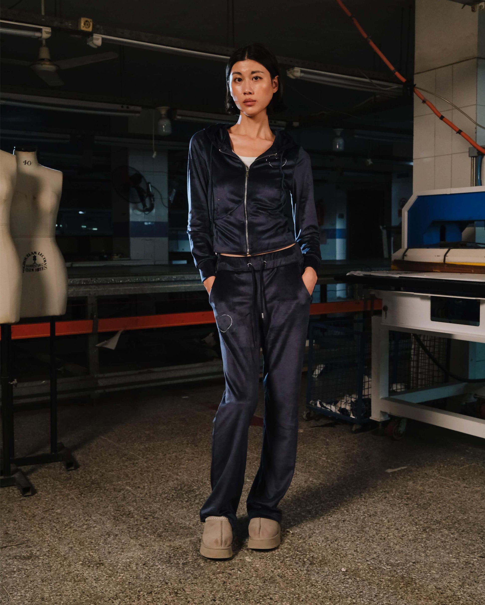 Person wearing a navy tracksuit in a workshop setting