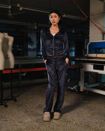 Person wearing a navy tracksuit in a workshop setting