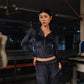 Woman wearing a black jacket and pants in an indoor setting