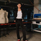 Person standing in a workshop with sewing machines and mannequins in the background