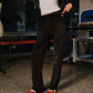 Person wearing black pants and red shoes in a workshop setting