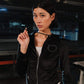 Woman wearing a black jacket with a heart design in an indoor setting