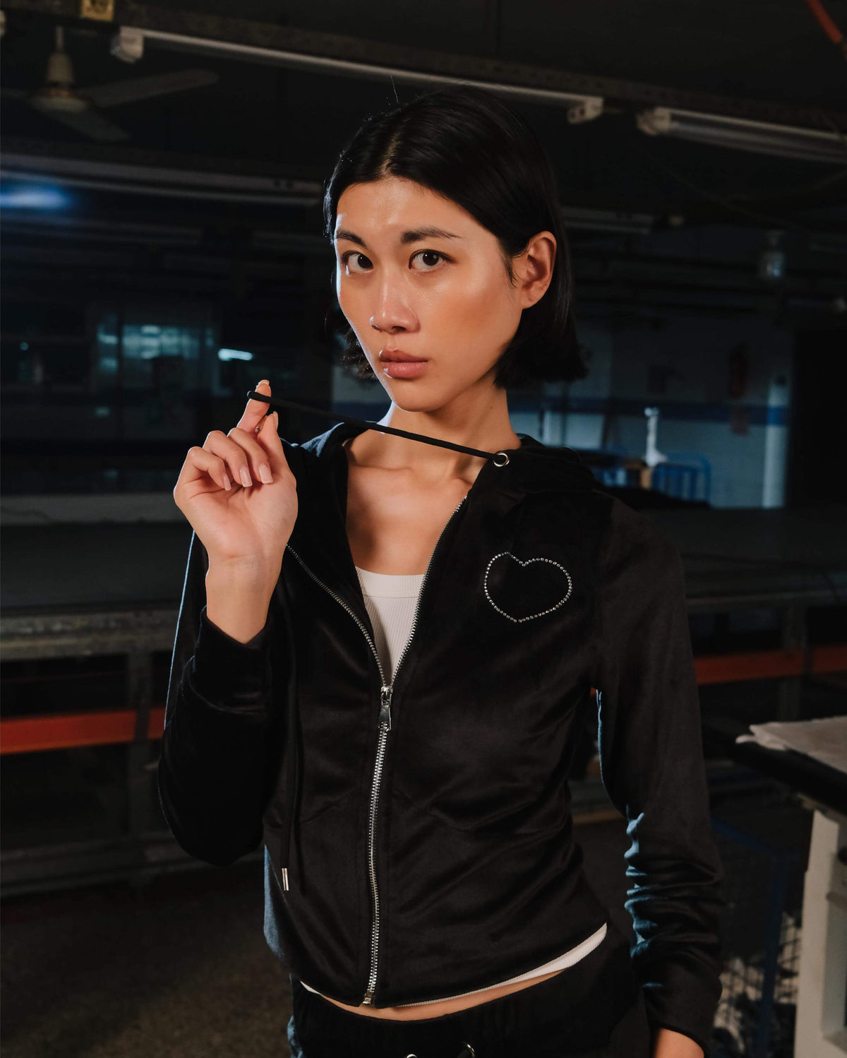 Woman wearing a black jacket with a heart design in an indoor setting