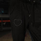 Black pants with a heart-shaped design on the leg, blurred background