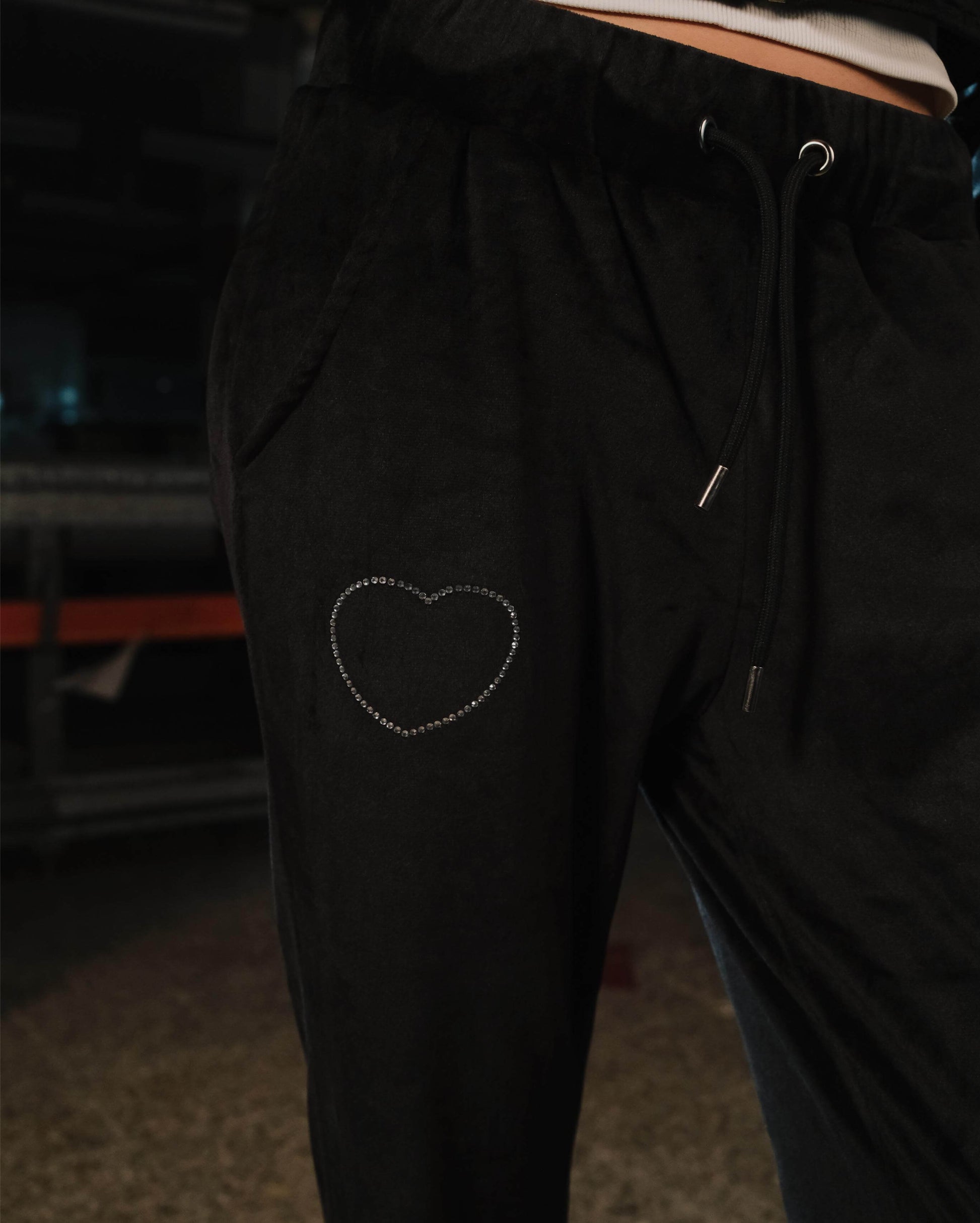 Black pants with a heart-shaped design on the leg, blurred background